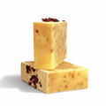 Two stacked soap bars with visible tea leaves on a white background