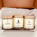 Three candles with labels 'Saffron Cedarwood', 'Serenity', and 'Opulence' in a box.