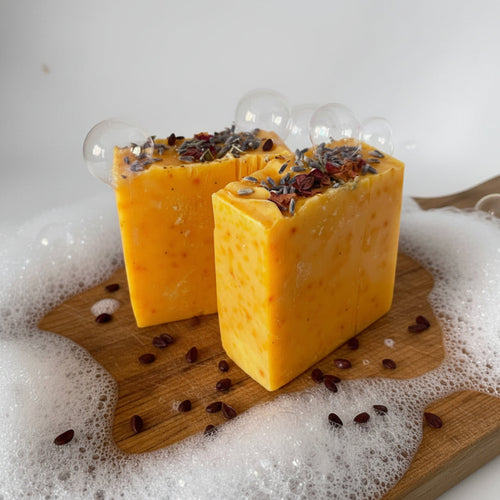 Two orange soap bars with lavender buds on a white background