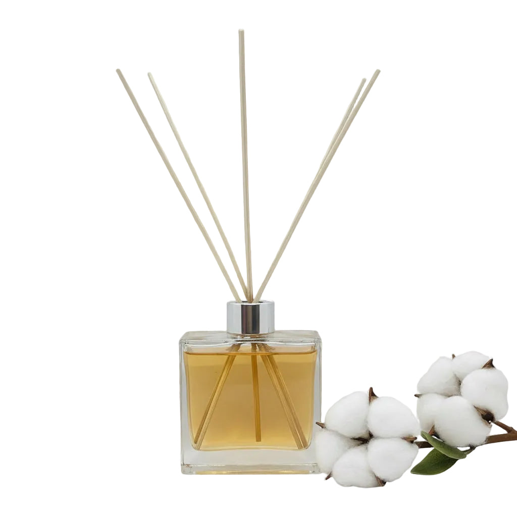Reed diffuser with wooden sticks in a clear glass bottle on a white background